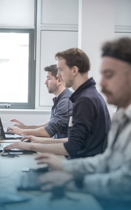 Photograph of three office workers at their desks