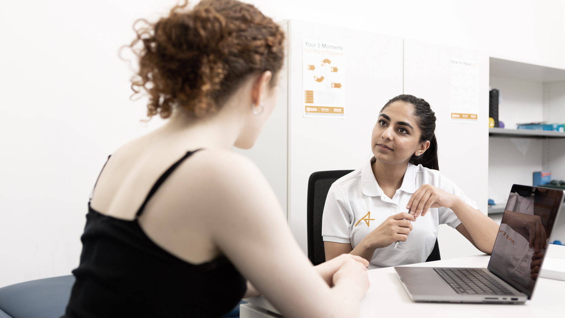 Photograph of Ascenti Physiotherapist speaking to patient at desk