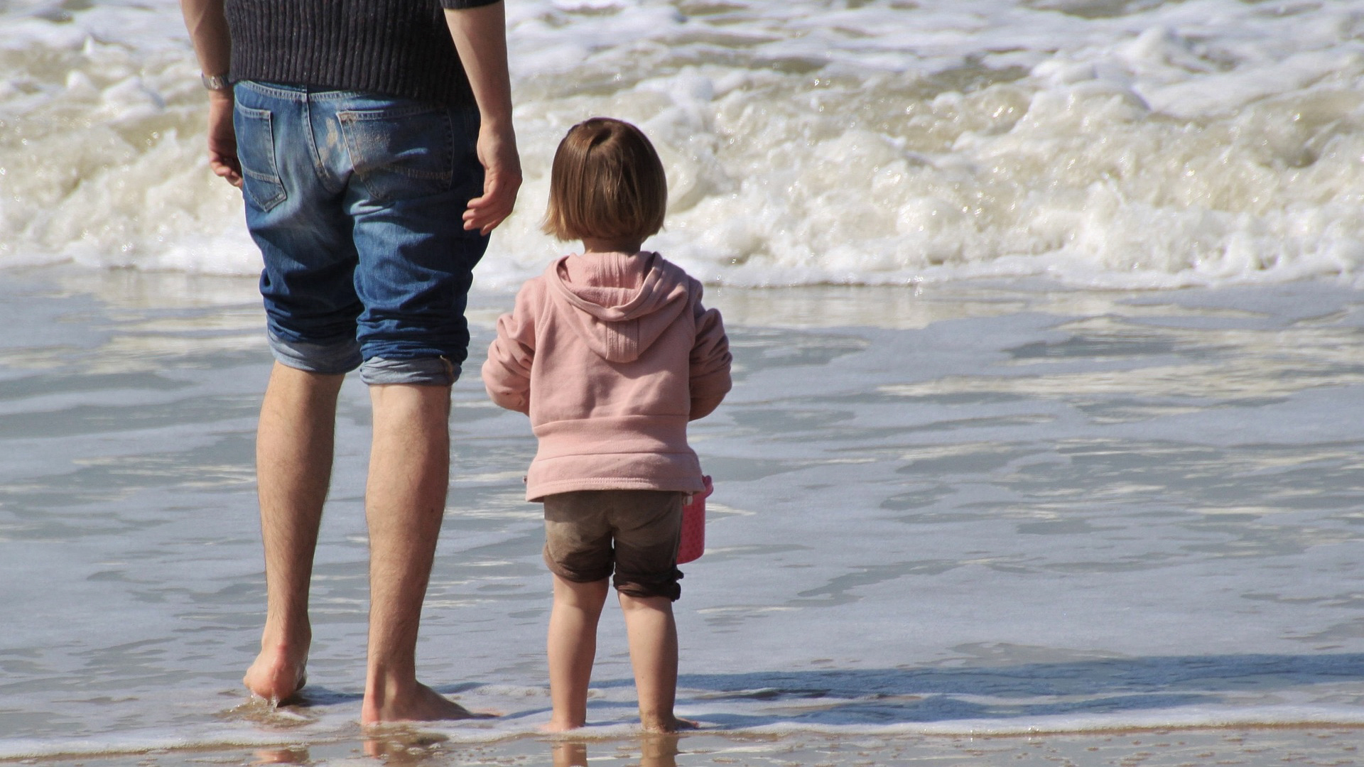 Photograph of man and child at beach