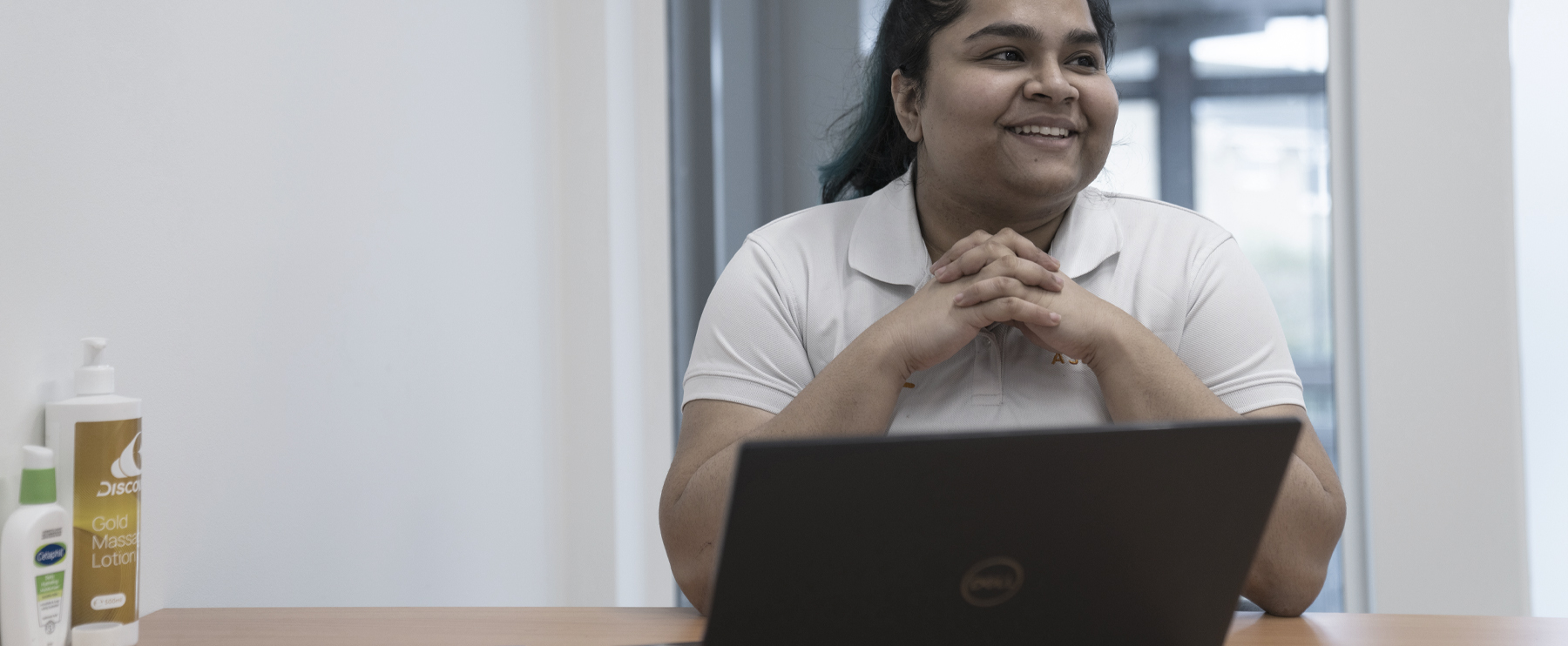 Photograph of Ascenti Physiotherapist smiling at their desk