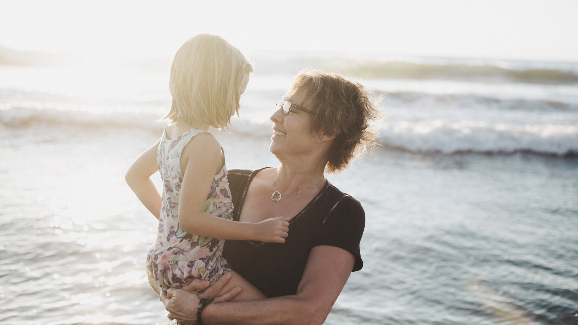 Photo of woman on beach carrying child