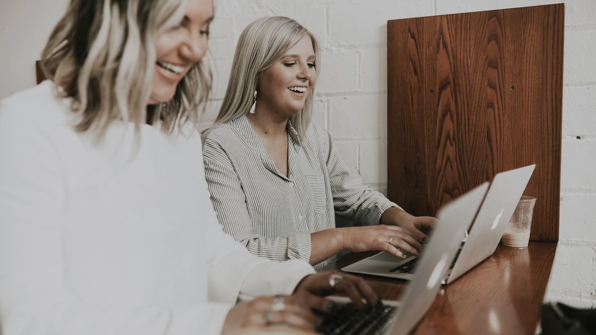 Photograph of two women working on laptops