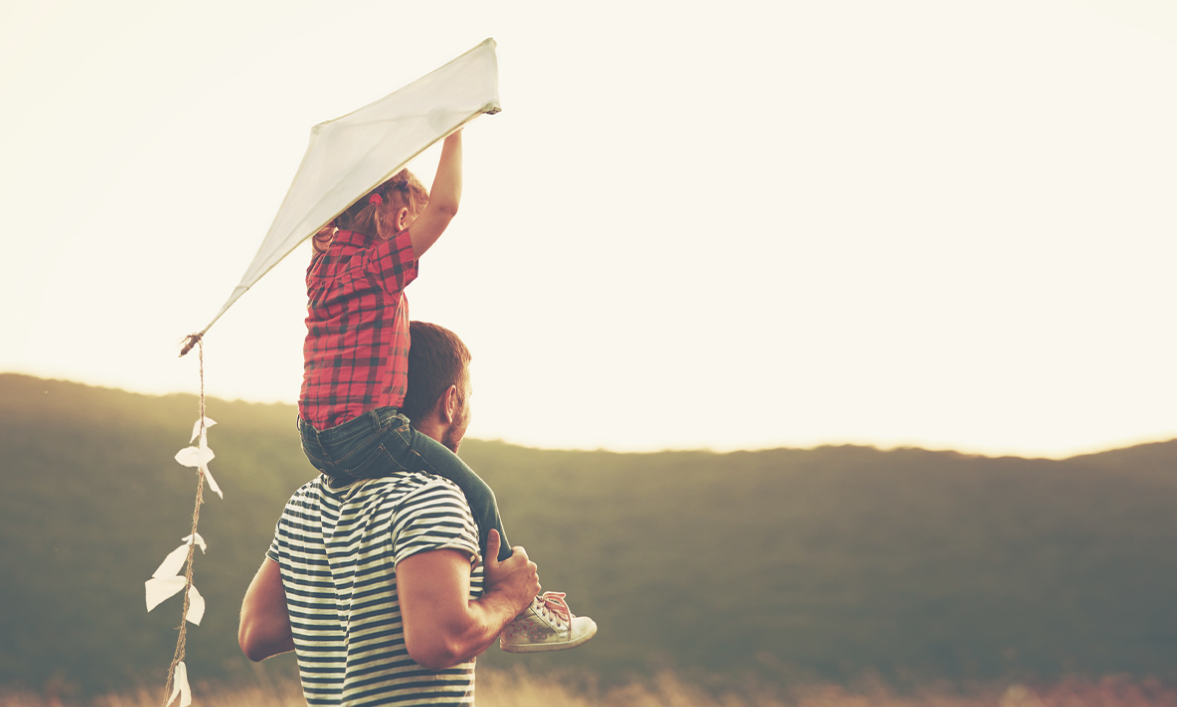 Photo of man carrying child on his shoulders