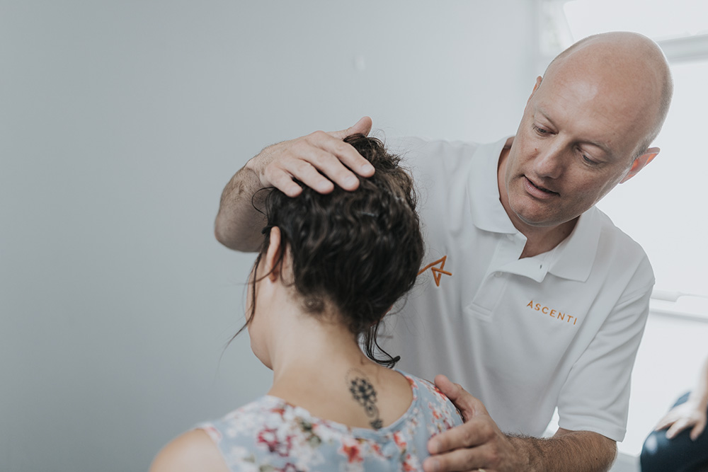Ascenti physio administering treatment for a neck complaint