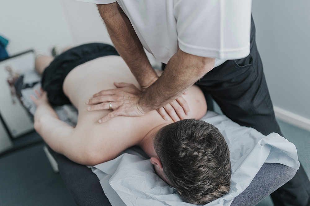 Ascenti patient receiving manual therapy on their back